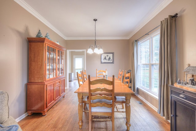 dining room with a notable chandelier, light hardwood / wood-style floors, and ornamental molding