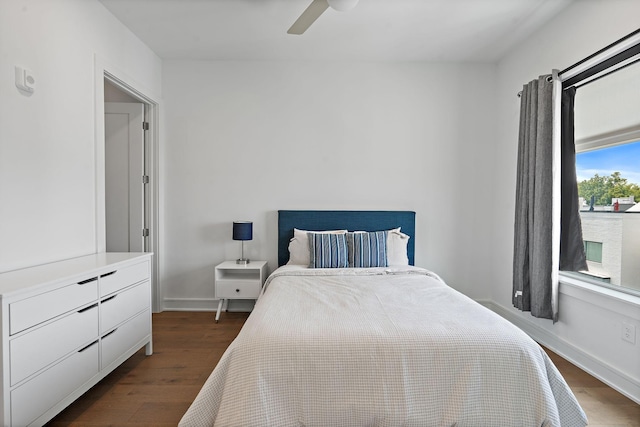 bedroom with multiple windows, ceiling fan, and dark hardwood / wood-style flooring