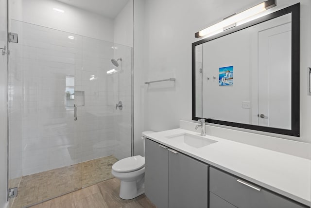 bathroom with vanity, wood-type flooring, an enclosed shower, and toilet