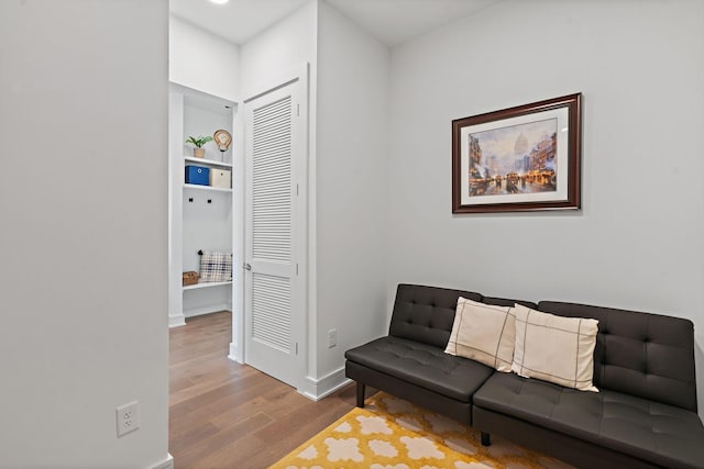 living area with hardwood / wood-style flooring and built in features