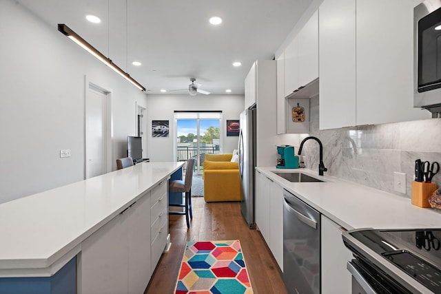 kitchen featuring sink, ceiling fan, appliances with stainless steel finishes, tasteful backsplash, and white cabinetry