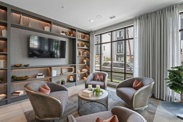 sitting room featuring light tile patterned floors, built in features, and plenty of natural light