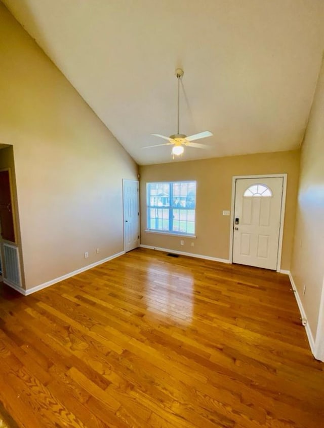 foyer entrance with ceiling fan, wood-type flooring, and vaulted ceiling