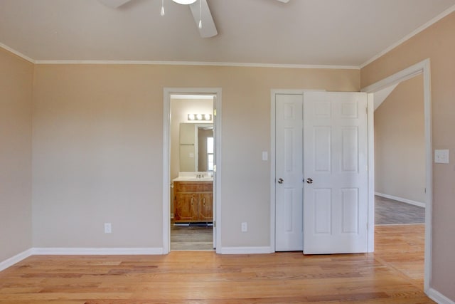 unfurnished bedroom featuring light wood-style floors, baseboards, and ornamental molding