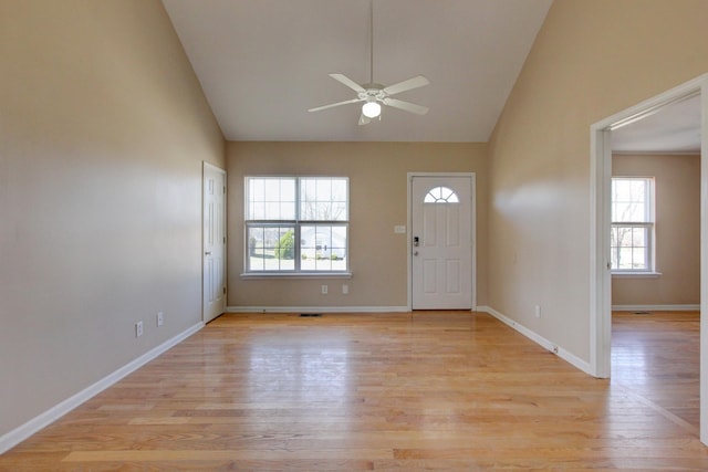 entrance foyer with high vaulted ceiling, baseboards, light wood-style floors, and a ceiling fan