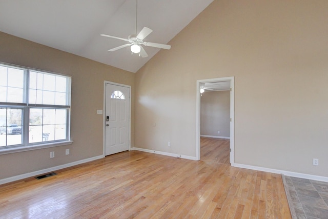 foyer with light wood-type flooring, visible vents, high vaulted ceiling, baseboards, and ceiling fan