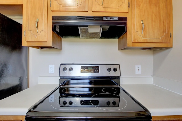 kitchen featuring light countertops, stainless steel range with electric stovetop, and exhaust hood