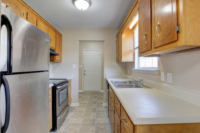 kitchen with a sink, appliances with stainless steel finishes, light countertops, and under cabinet range hood