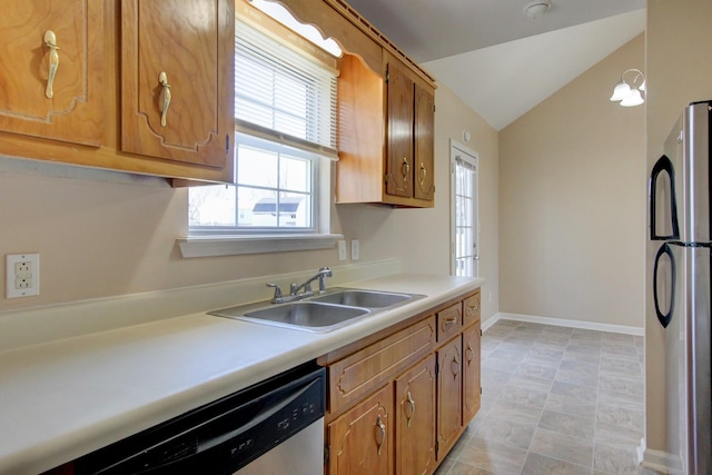 kitchen with baseboards, a sink, vaulted ceiling, light countertops, and appliances with stainless steel finishes