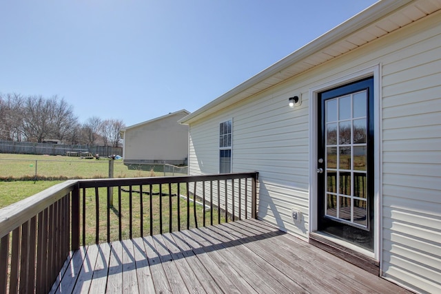 wooden deck with a lawn and fence