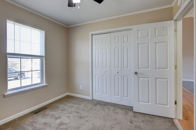 unfurnished bedroom featuring visible vents, baseboards, a closet, and ornamental molding