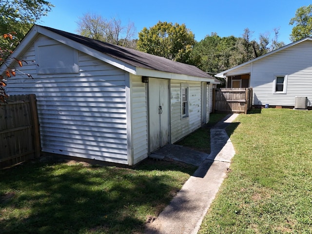 view of outbuilding featuring a lawn and central AC