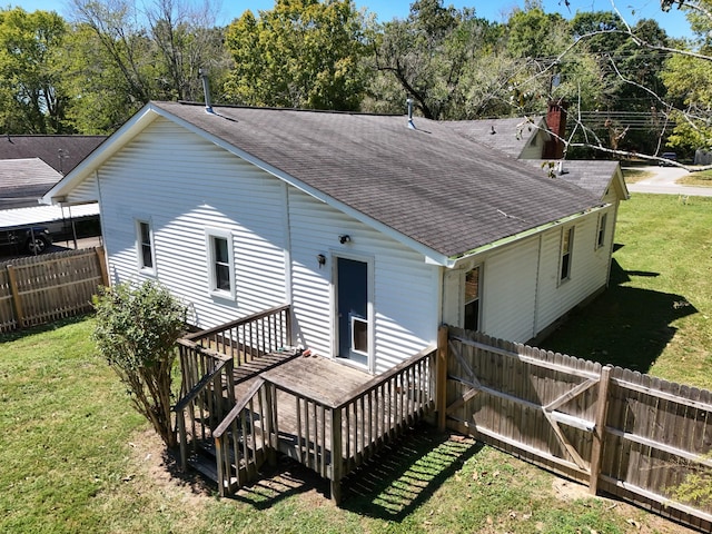 back of property featuring a lawn and a deck