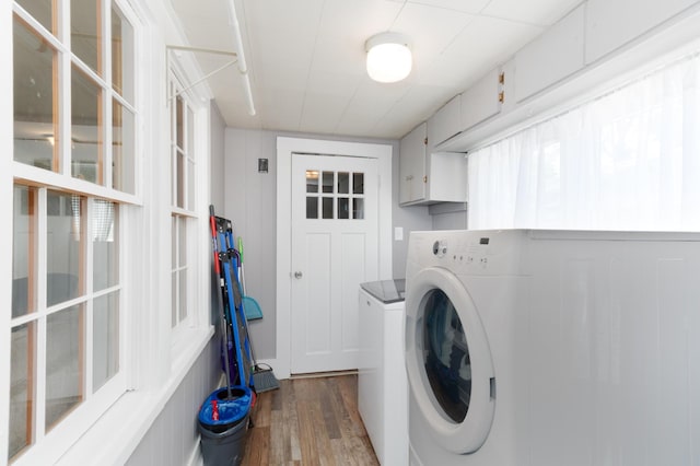 washroom with cabinets, wood-type flooring, and separate washer and dryer