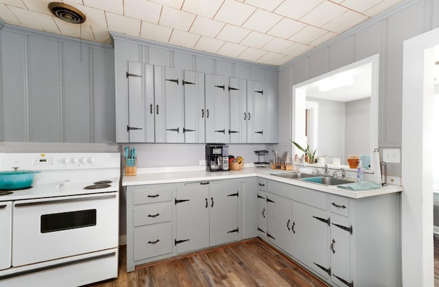 kitchen with gray cabinetry, white electric range, sink, and dark wood-type flooring