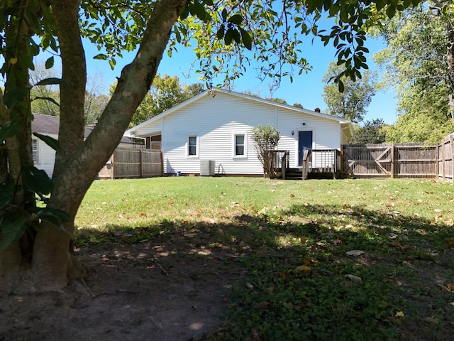 back of house with a deck, a yard, and central AC