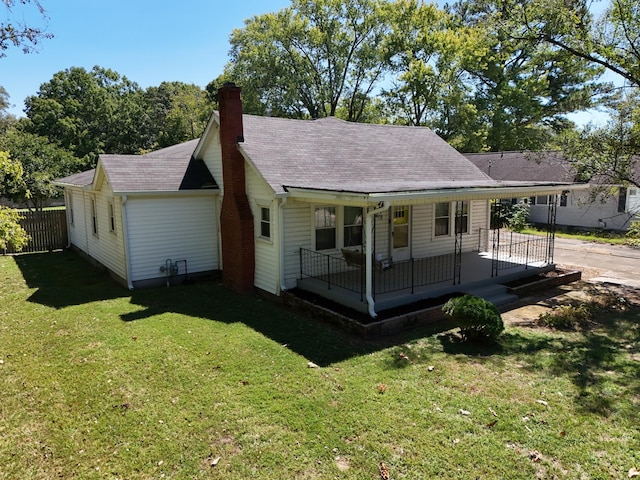 back of house with a lawn and covered porch