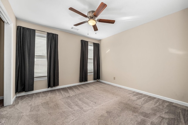 empty room featuring ceiling fan and light carpet