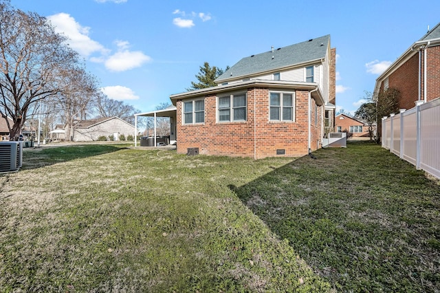 rear view of house featuring a yard and central AC unit