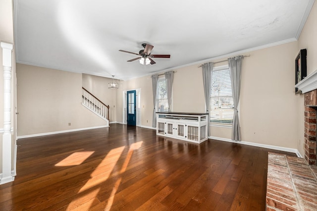 unfurnished living room with a fireplace, ceiling fan with notable chandelier, crown molding, and dark wood-type flooring