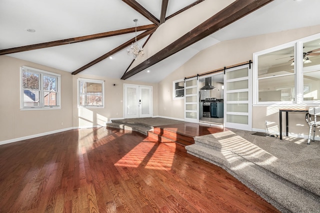 recreation room with french doors, ceiling fan, lofted ceiling with beams, a barn door, and hardwood / wood-style flooring