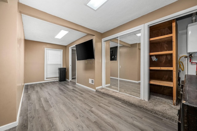 empty room featuring wood-type flooring and water heater