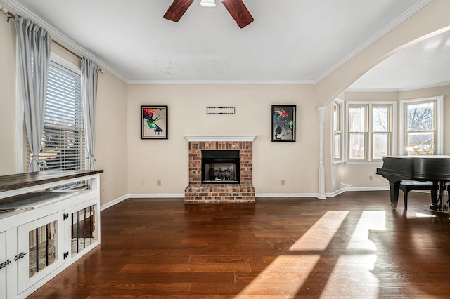 living room with a brick fireplace, plenty of natural light, and ornamental molding