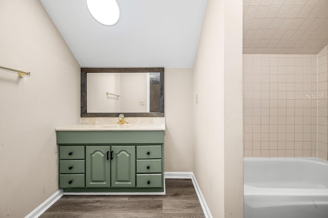 bathroom featuring vanity, wood-type flooring, lofted ceiling, and tiled shower / bath combo