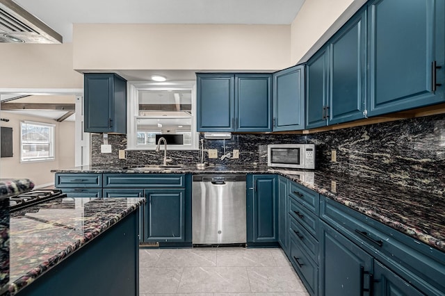 kitchen featuring blue cabinetry, dark stone countertops, sink, and stainless steel appliances