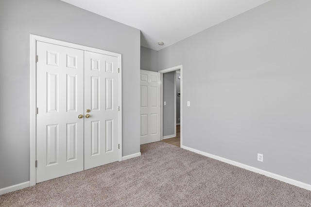 unfurnished bedroom with light colored carpet and a closet