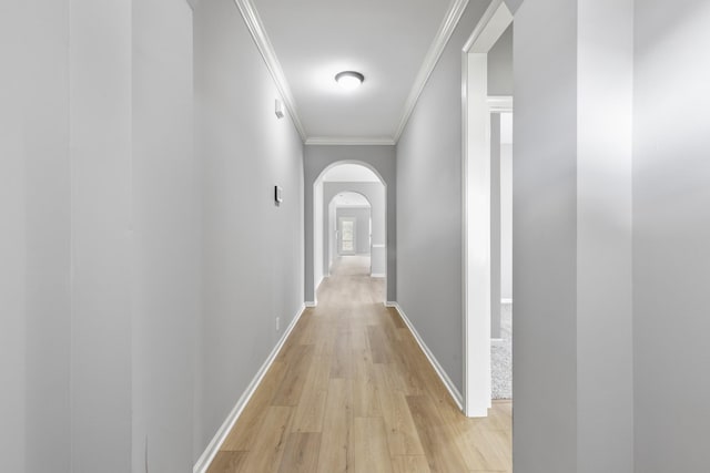 corridor with light wood-type flooring and ornamental molding