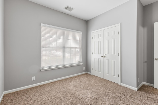 unfurnished bedroom with carpet floors and a closet