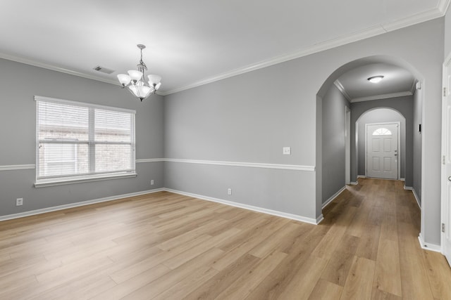 empty room with crown molding, a chandelier, and light hardwood / wood-style floors