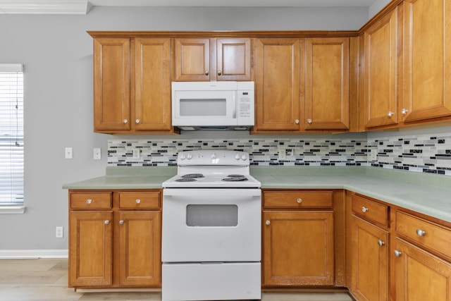 kitchen featuring decorative backsplash, white appliances, and plenty of natural light