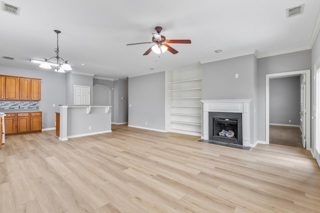 unfurnished living room featuring light wood-type flooring, ceiling fan with notable chandelier, and ornamental molding