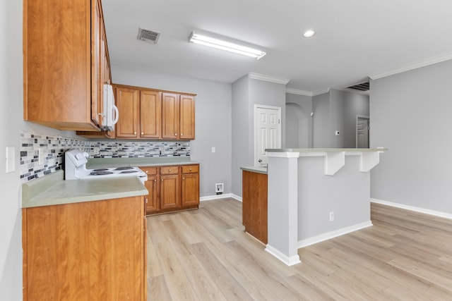 kitchen featuring a kitchen bar, tasteful backsplash, ornamental molding, white range with electric stovetop, and light hardwood / wood-style floors