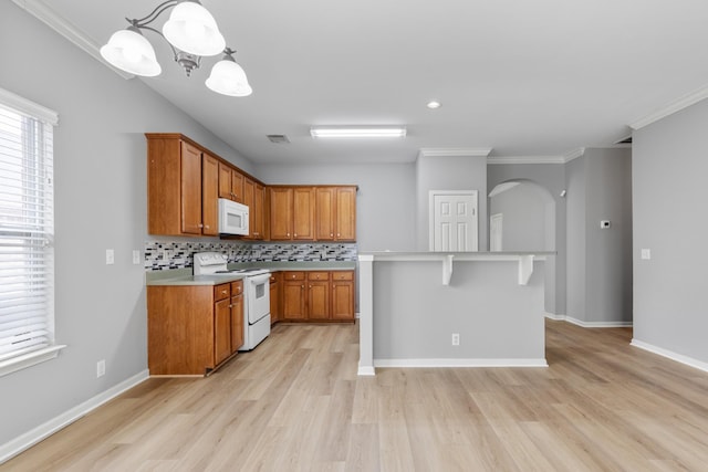 kitchen with tasteful backsplash, a chandelier, pendant lighting, white appliances, and ornamental molding