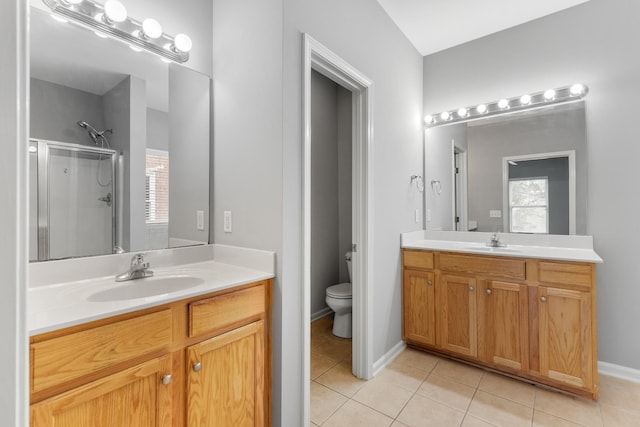 bathroom featuring tile patterned floors, vanity, toilet, and an enclosed shower