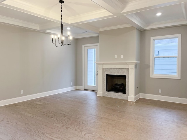 unfurnished living room featuring coffered ceiling, crown molding, beam ceiling, an inviting chandelier, and a tiled fireplace