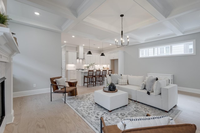 living room with beamed ceiling, an inviting chandelier, coffered ceiling, and a premium fireplace