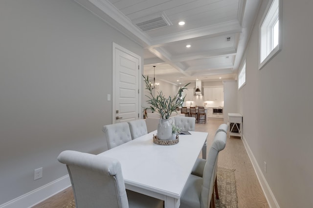 dining area with hardwood / wood-style floors, an inviting chandelier, coffered ceiling, crown molding, and beamed ceiling