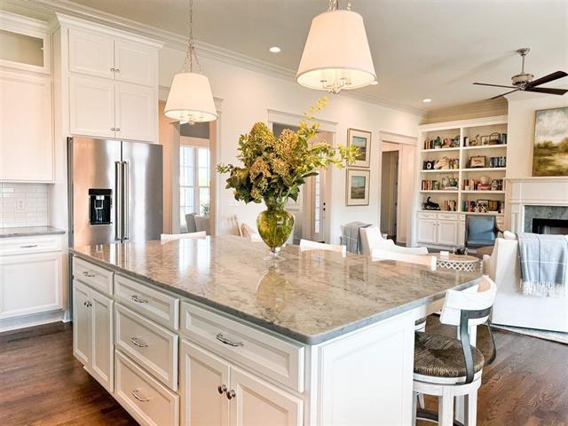 kitchen with high end fridge, decorative light fixtures, a center island, and a kitchen bar