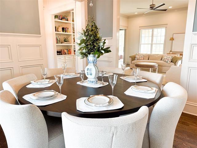 dining room with dark hardwood / wood-style flooring, crown molding, built in features, and ceiling fan