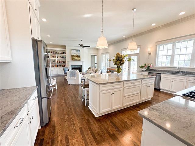 kitchen with stainless steel appliances, light stone countertops, and white cabinets