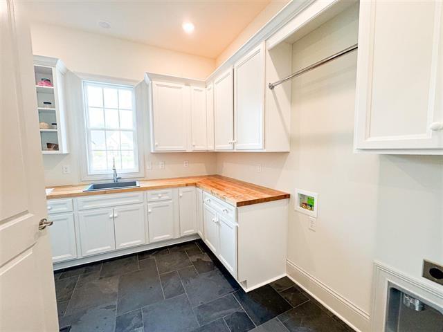 washroom featuring sink, hookup for a washing machine, and cabinets