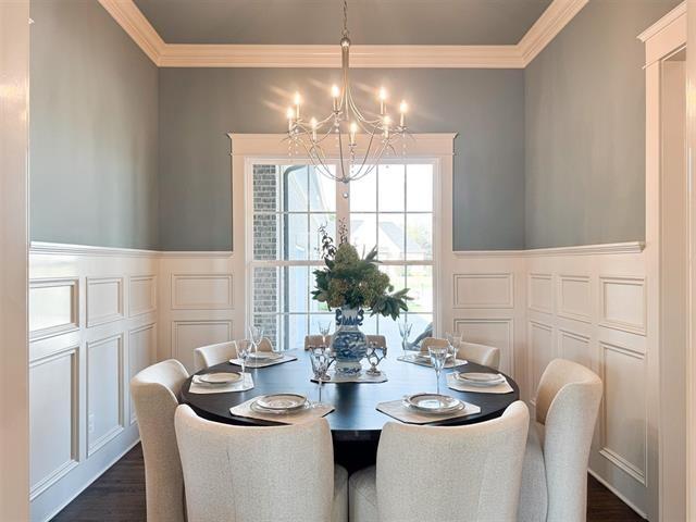 dining room with an inviting chandelier, dark hardwood / wood-style flooring, and ornamental molding