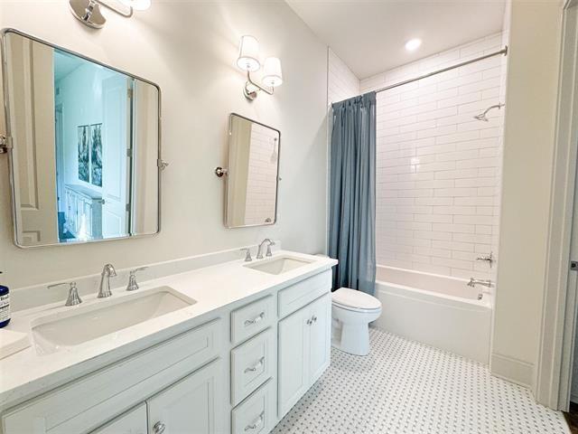 full bathroom with shower / bath combination with curtain, vanity, and toilet