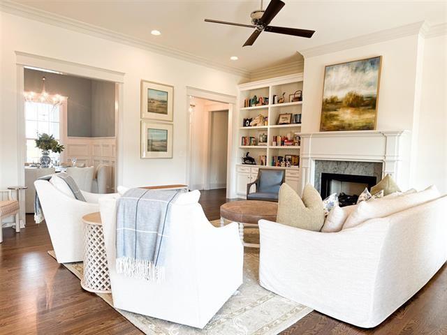 living room with crown molding, a fireplace, dark hardwood / wood-style floors, and ceiling fan