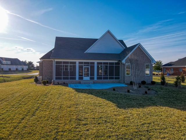 back of property featuring a sunroom and a lawn