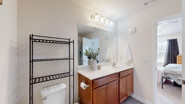 bathroom with toilet, ceiling fan, and vanity